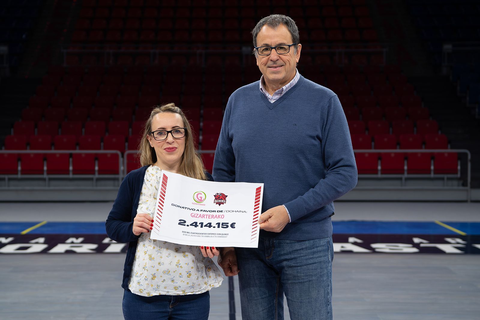 Gizarterako recibe el cheque con los fondos recaudados en la subasta One Team