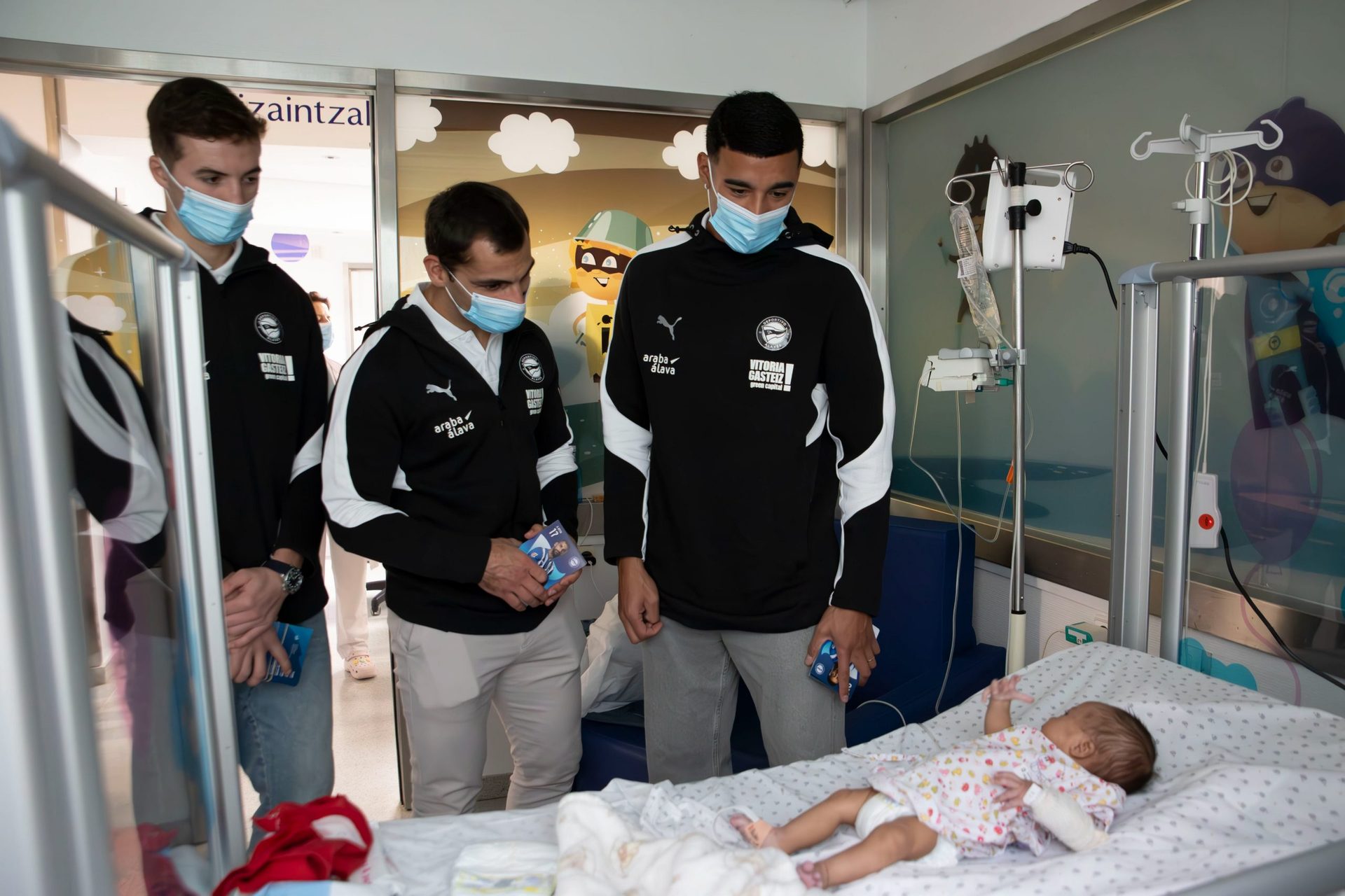 Los jugadores albiazules Carlos Protesoni, Jonny Otto y Jon Pacheco visitan la planta de pediatría de Txagorritxu